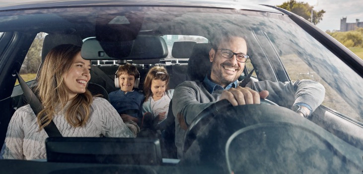 happy family enjoying while going on a vacation by car